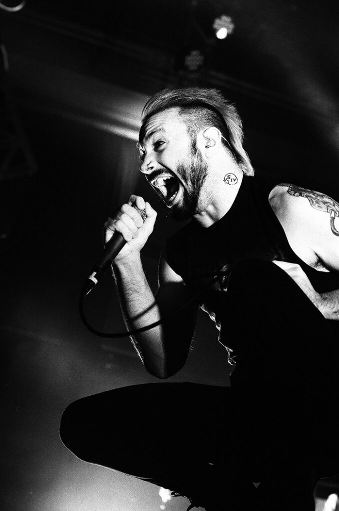 Singer passionately performing on stage, black-and-white.