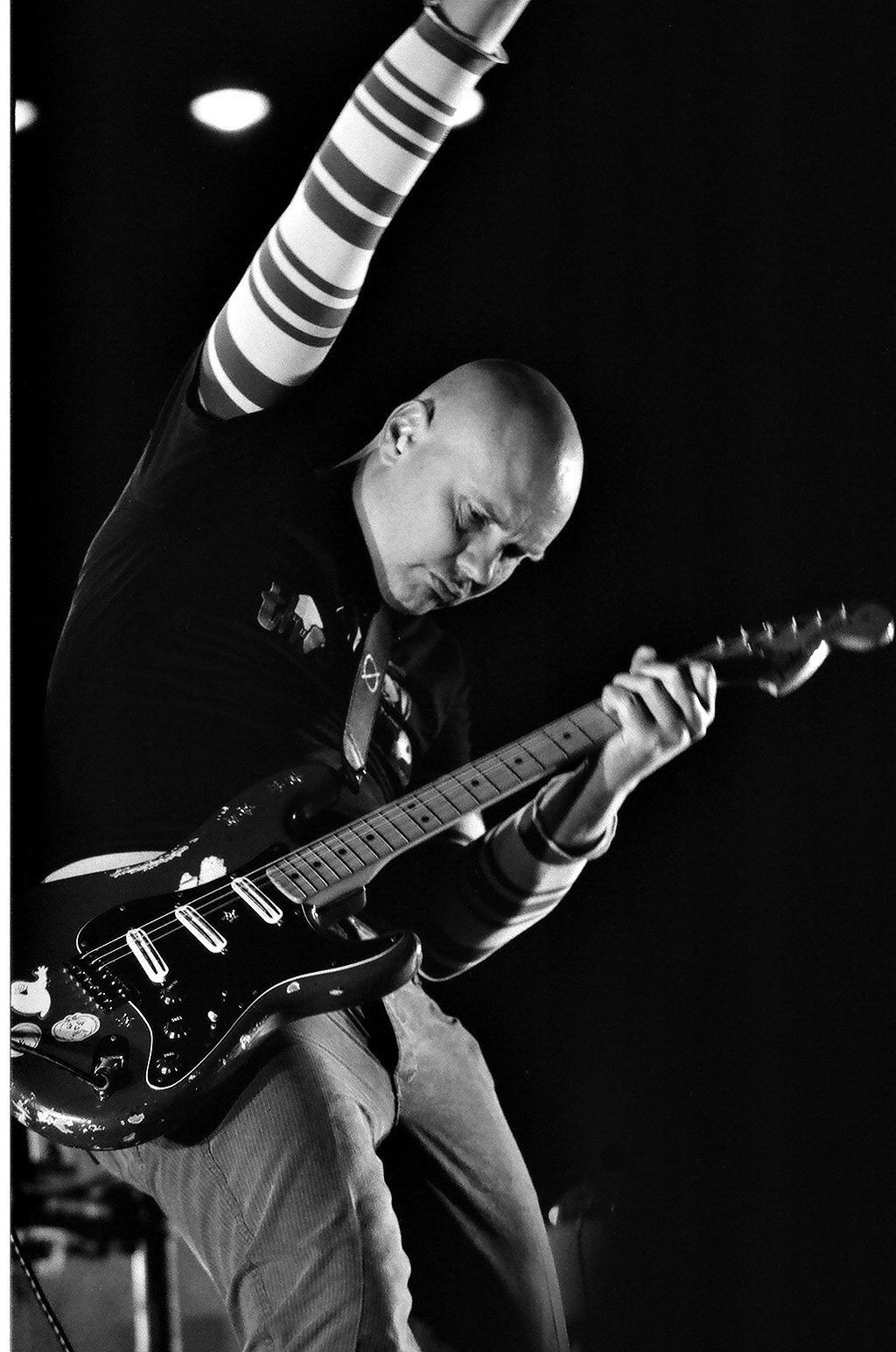 Guitarist performing energetically on stage.