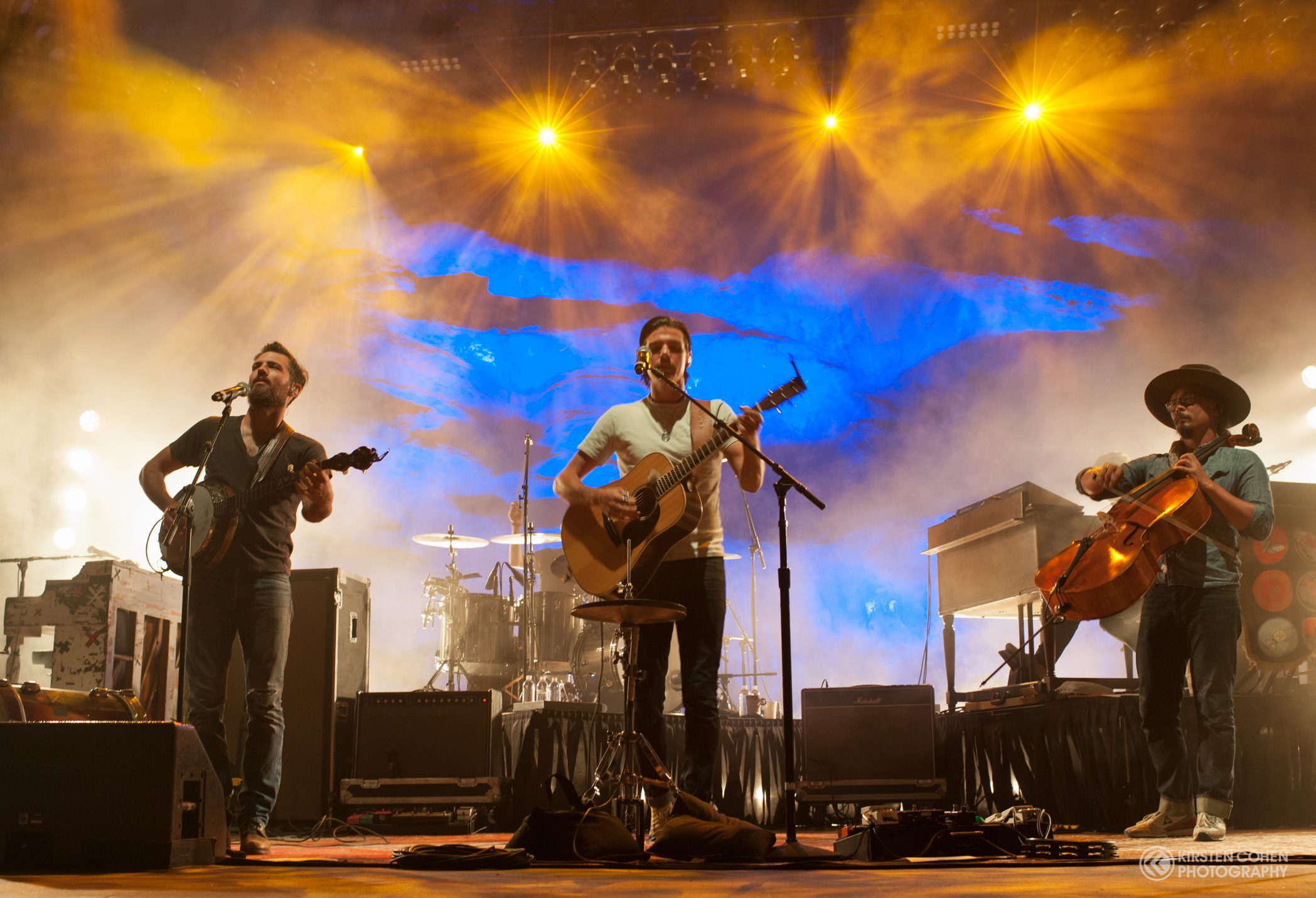 Band performing on stage with colorful lights.