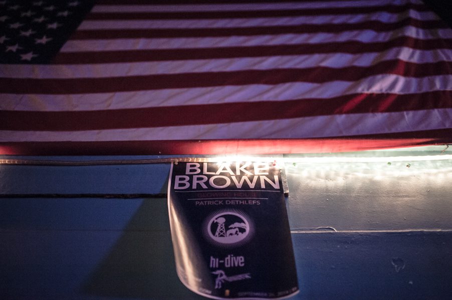 Concert poster under American flag with lights.