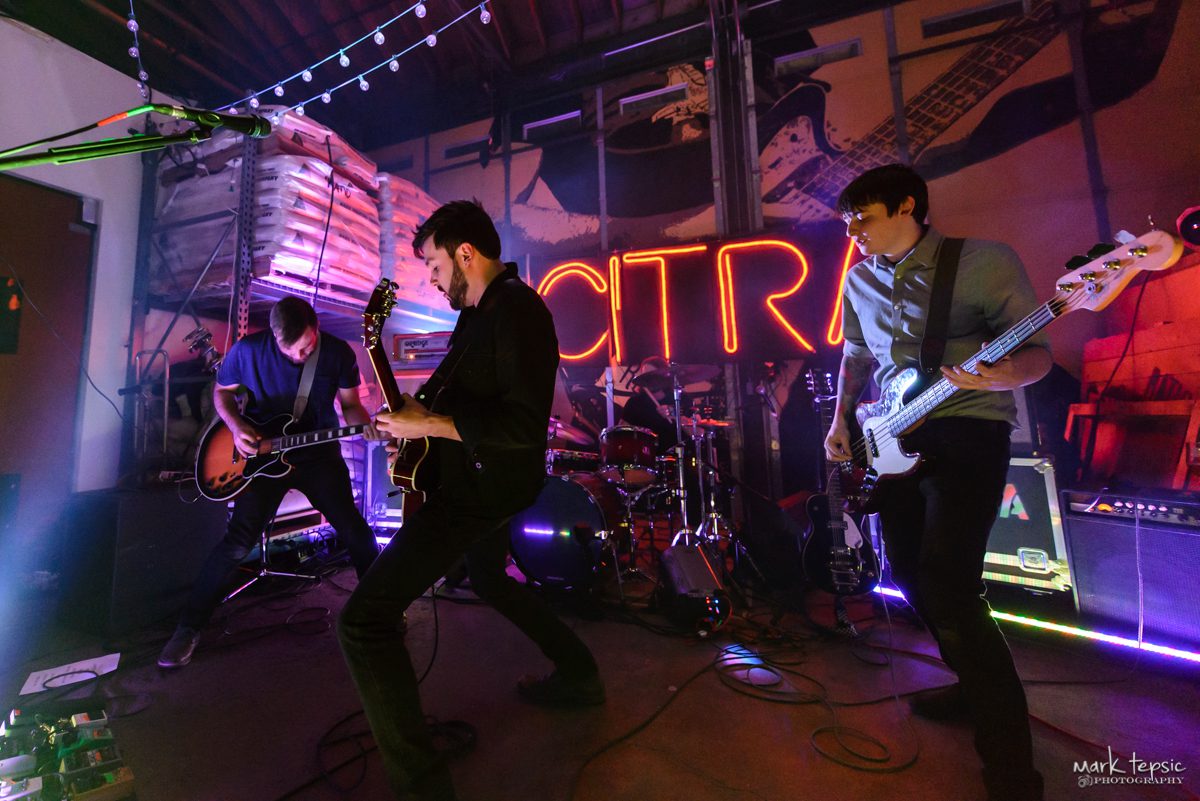 Band performing live on a dimly-lit stage.