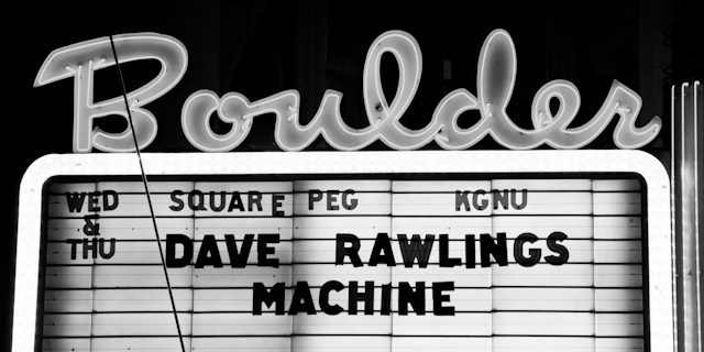 Neon "Boulder" sign with event announcement.