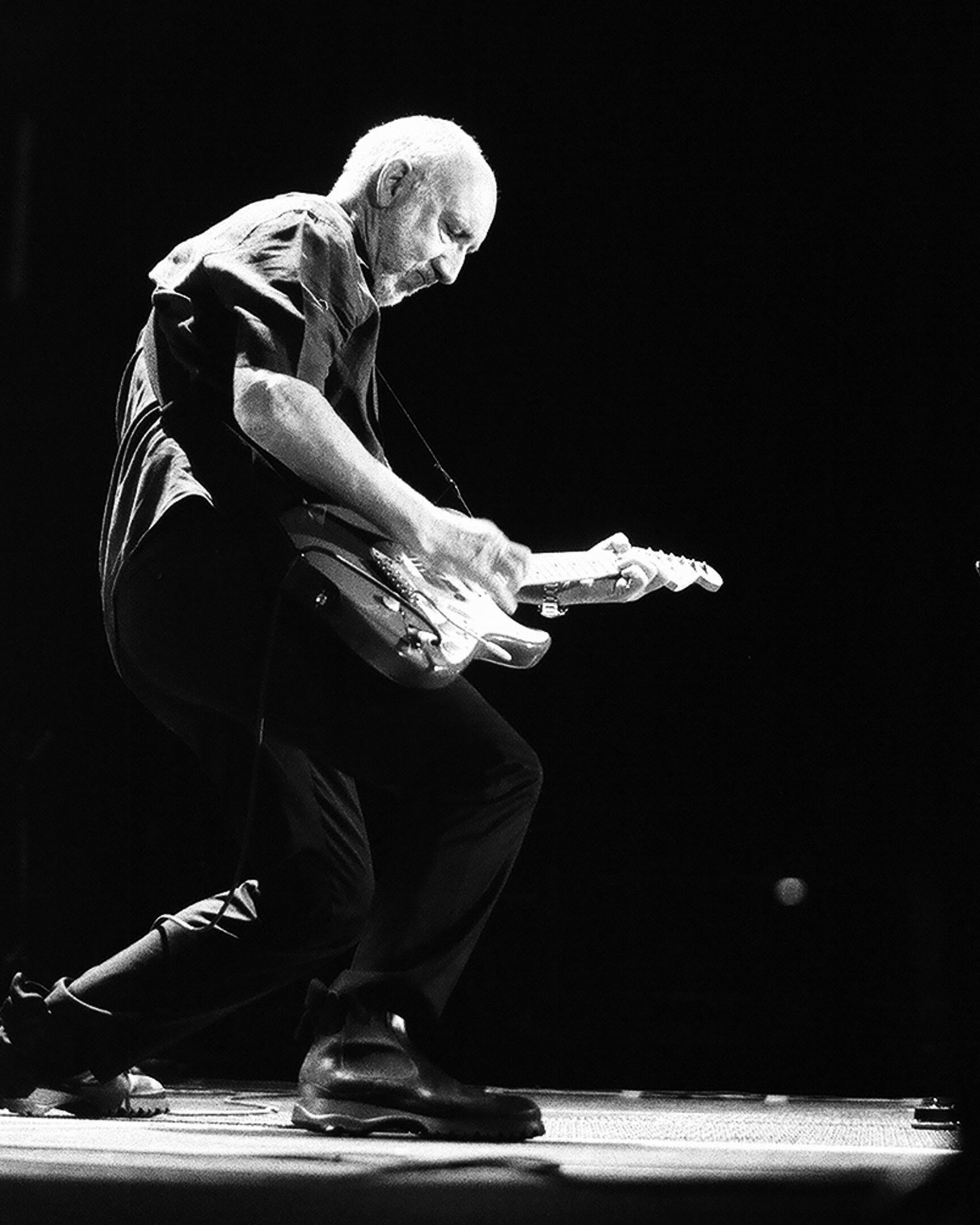 Guitarist passionately playing electric guitar on stage.