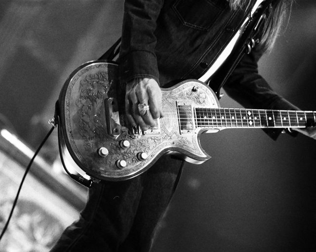 Guitarist playing electric guitar on stage.