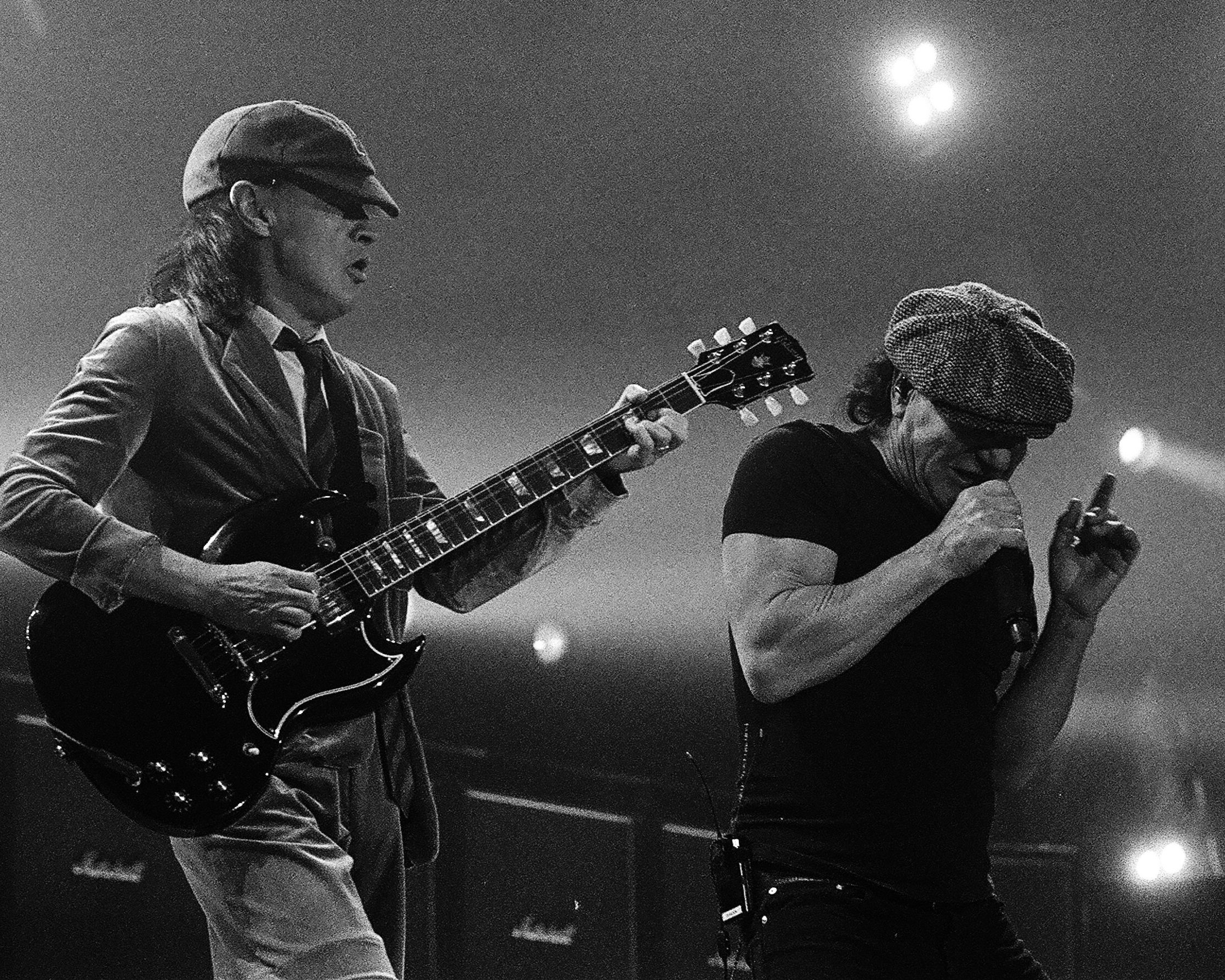 Two musicians performing on stage, black and white.