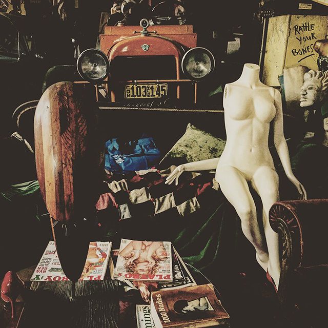 Vintage mannequin and car in eclectic room.