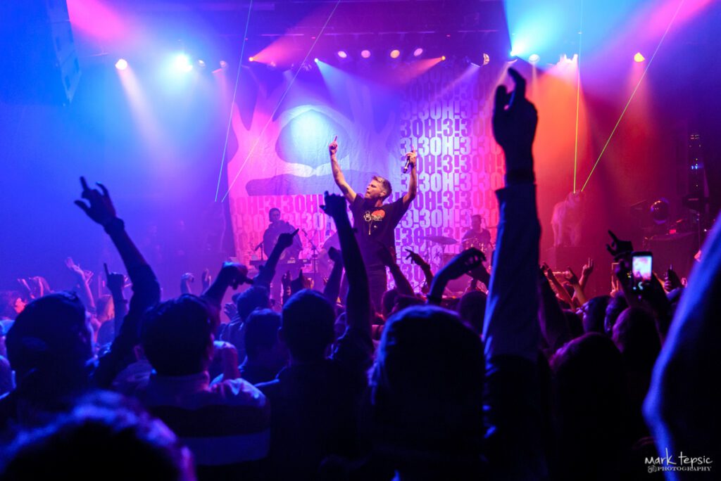 Concert crowd with vibrant stage lighting.
