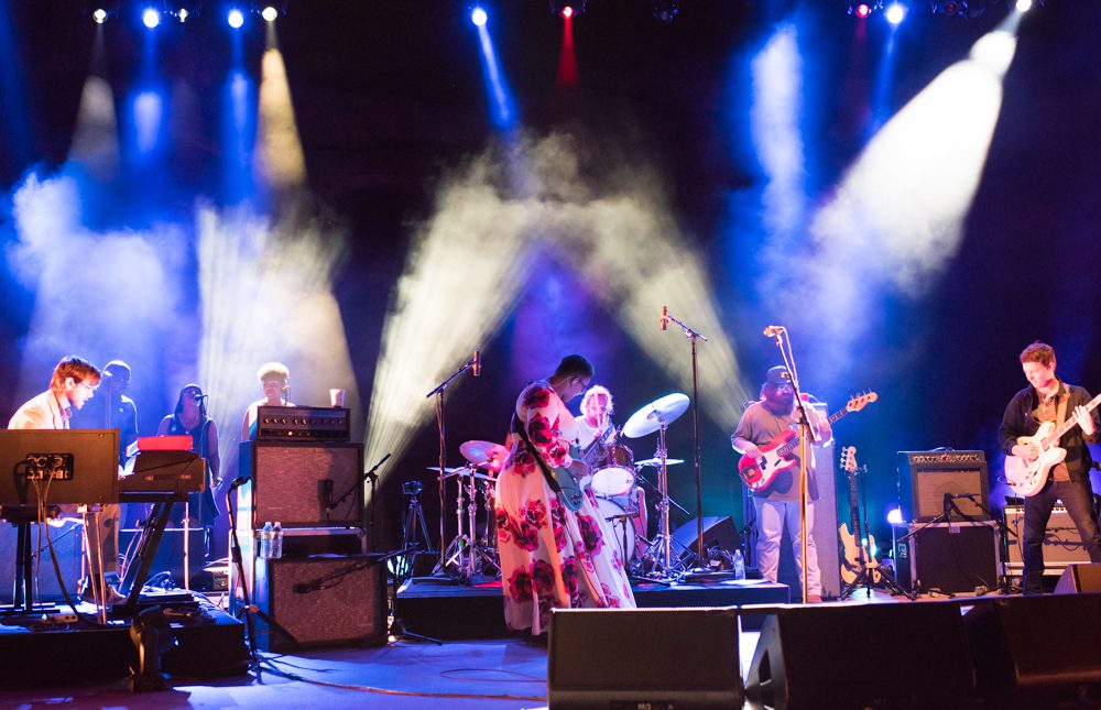 Band performing on stage with colorful lights.