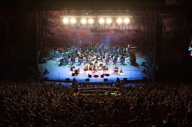 Concert orchestra performing at outdoor venue.