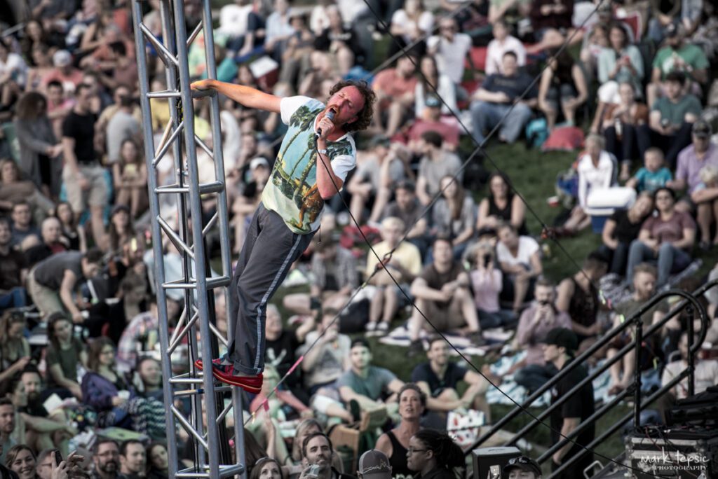 Performer climbing structure at outdoor concert.