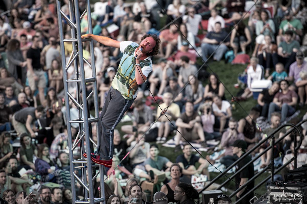 Performer climbing structure at outdoor concert.