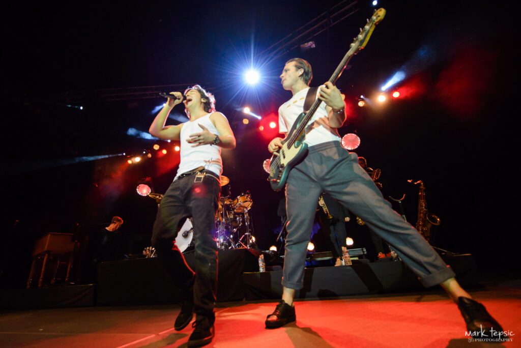 Live band performing energetically on stage.