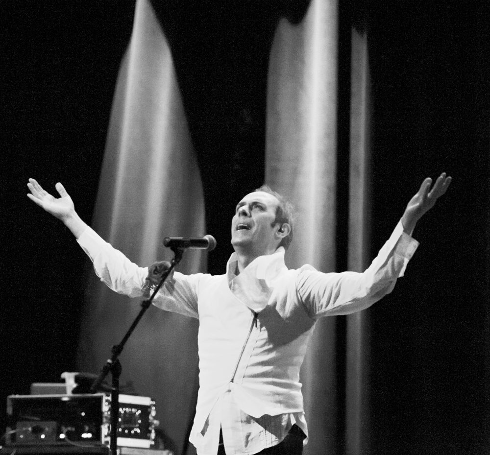 Performer on stage with arms raised.