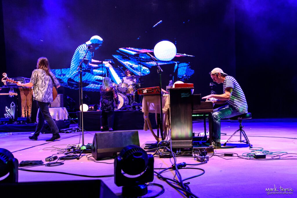 Musicians performing on stage with instruments.