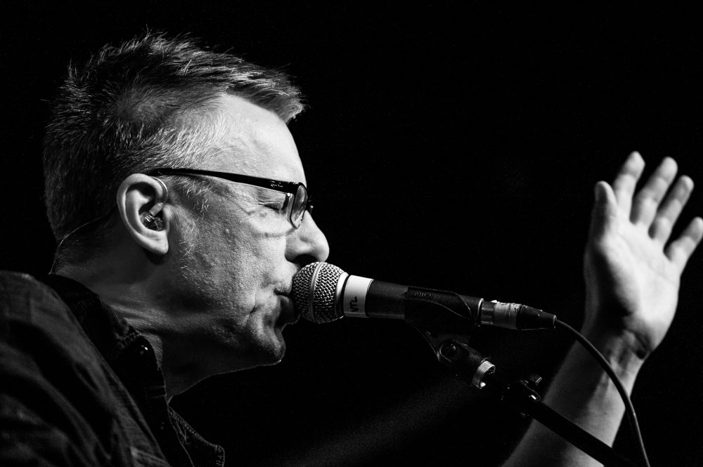 Singer performing on stage with microphone.