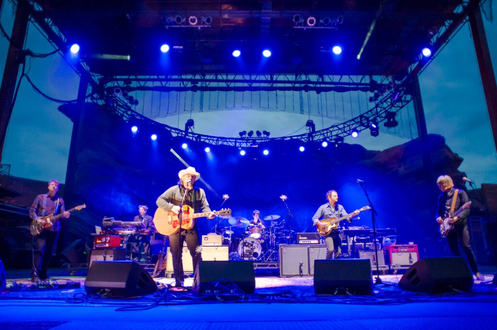 Band performing on an outdoor stage at night.