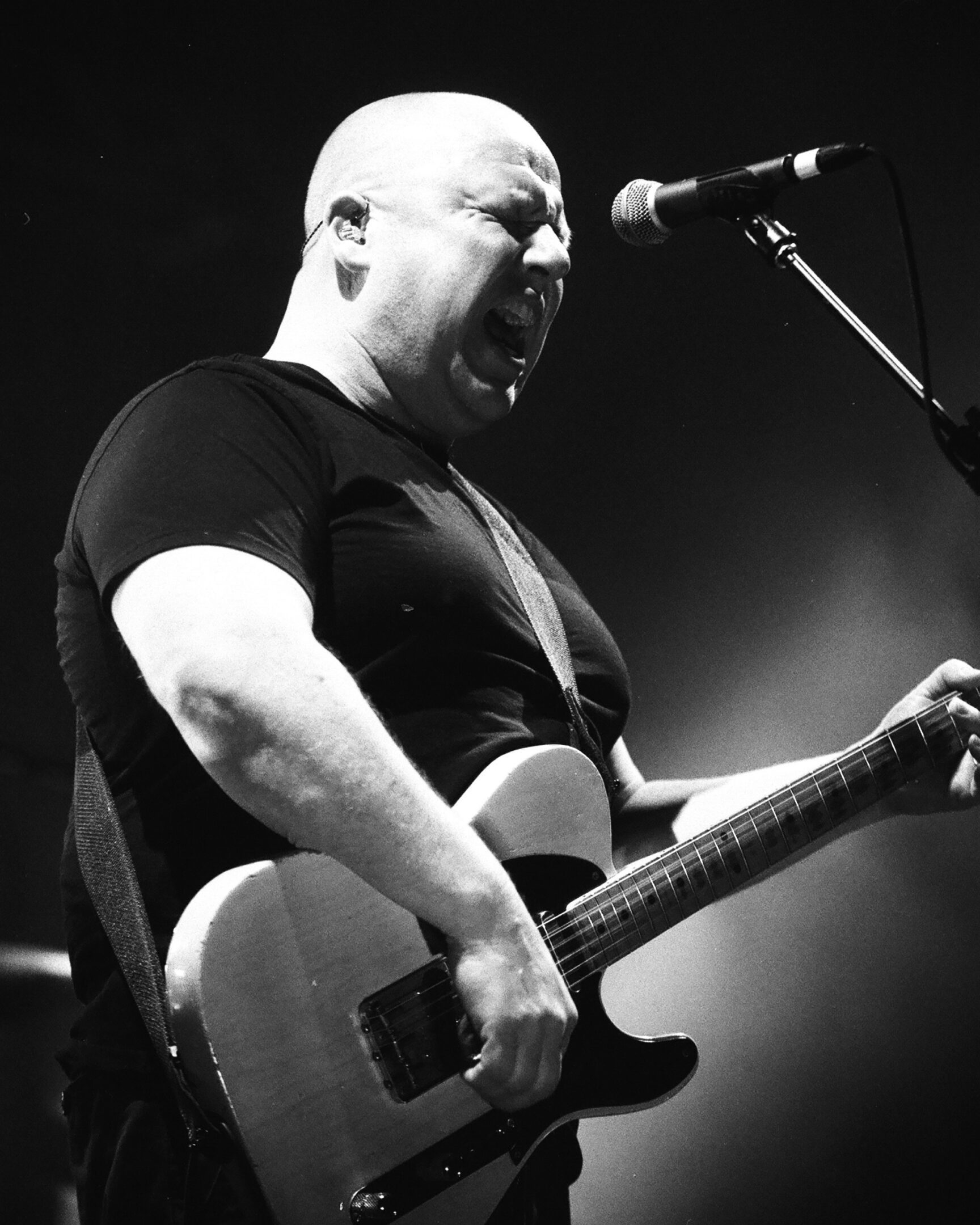 Musician passionately playing guitar on stage.