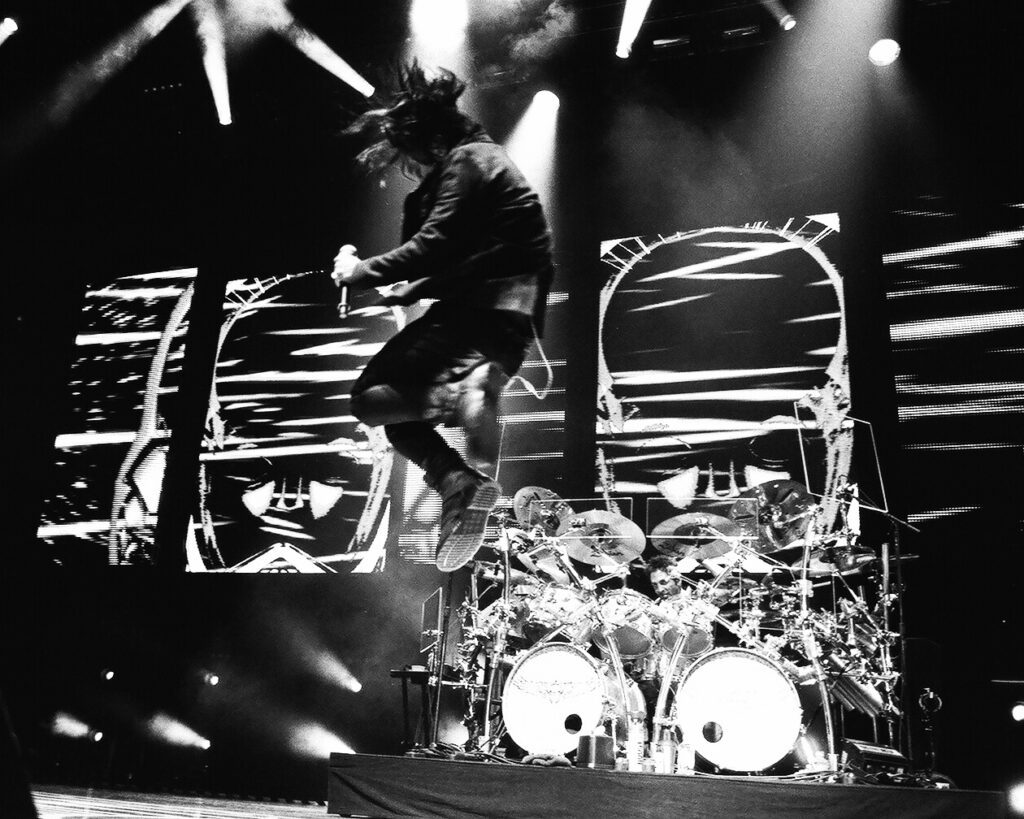Musician jumping energetically during a live concert.
