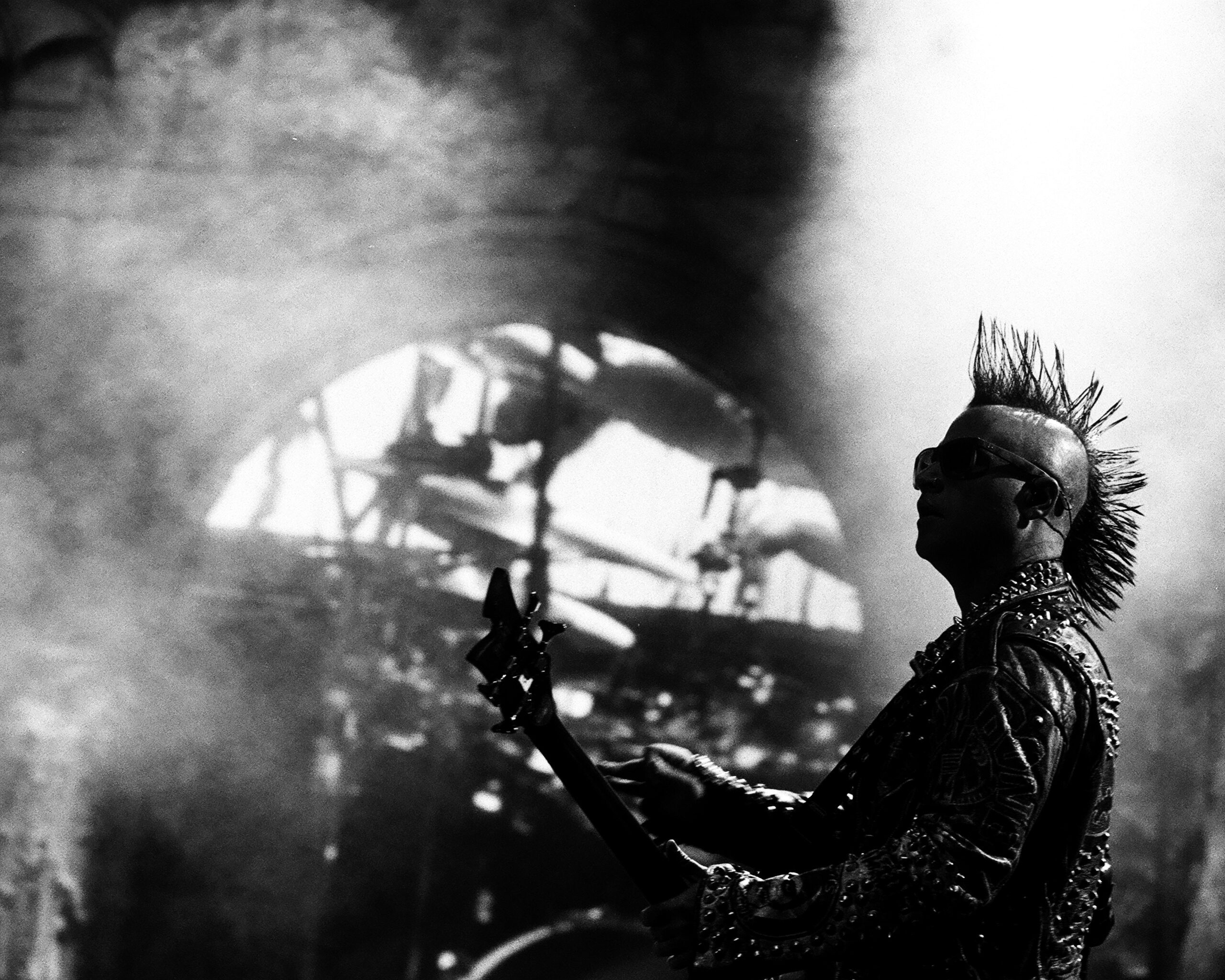 Punk musician playing guitar on stage.