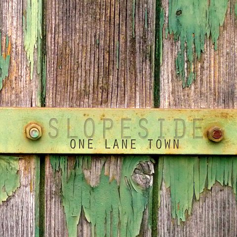 Weathered wood with "Slopeside One Lane Town.