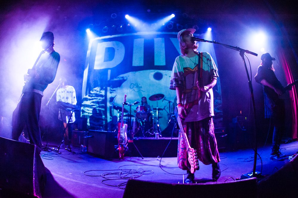 Band performing on stage with colorful lighting.