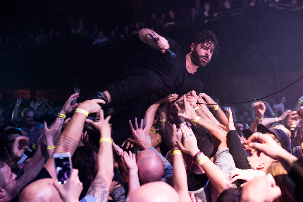 Singer crowd surfing during a live concert.