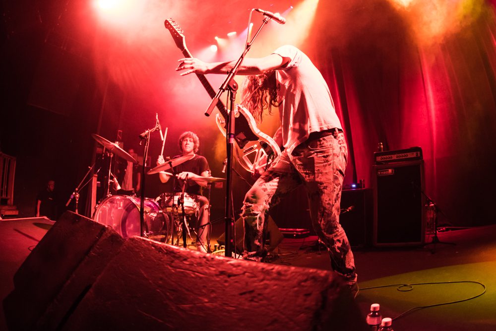 Rock band performing energetically on stage.