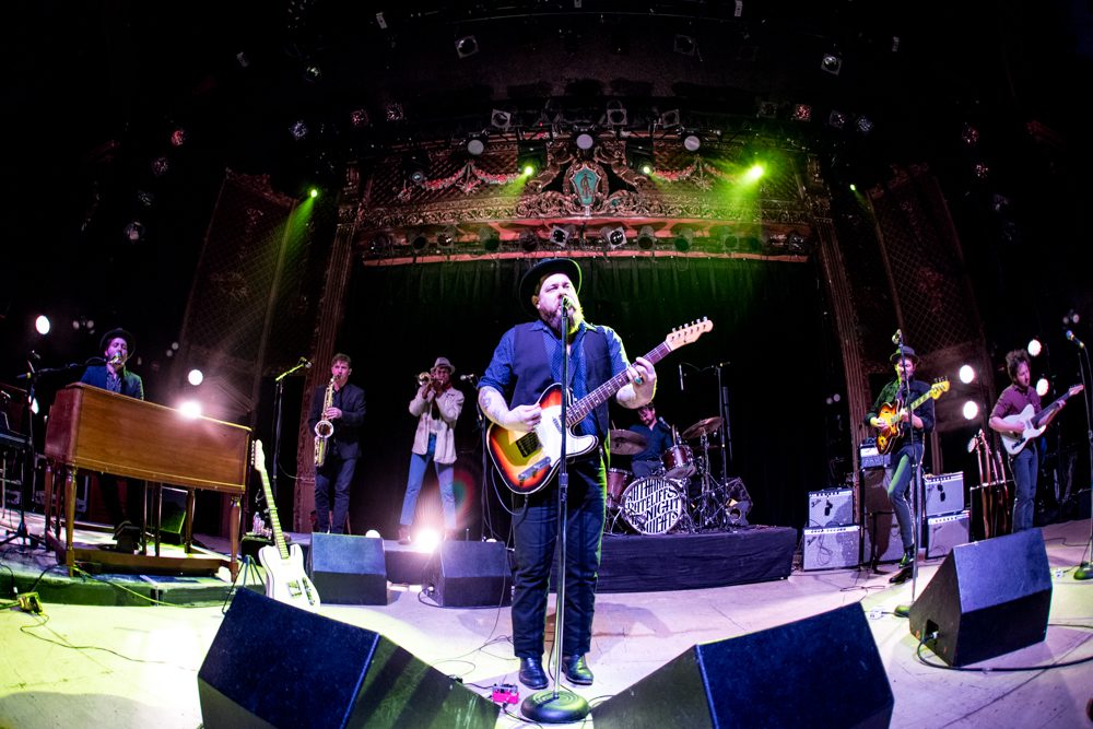 Band performing on stage with instruments.