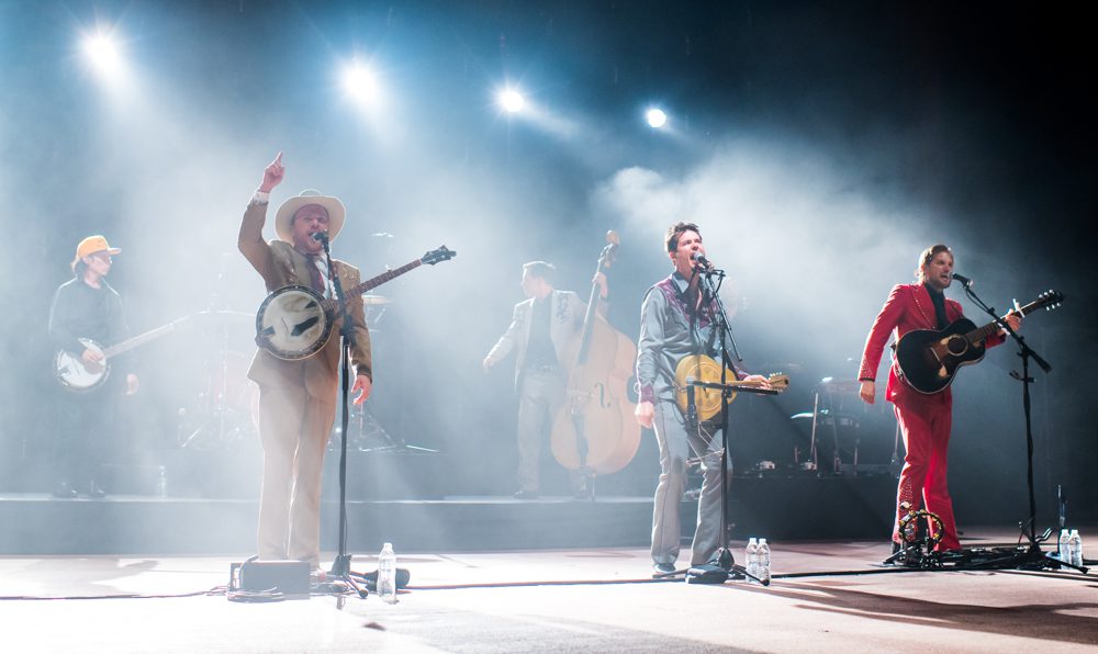Band performing on stage with various instruments.