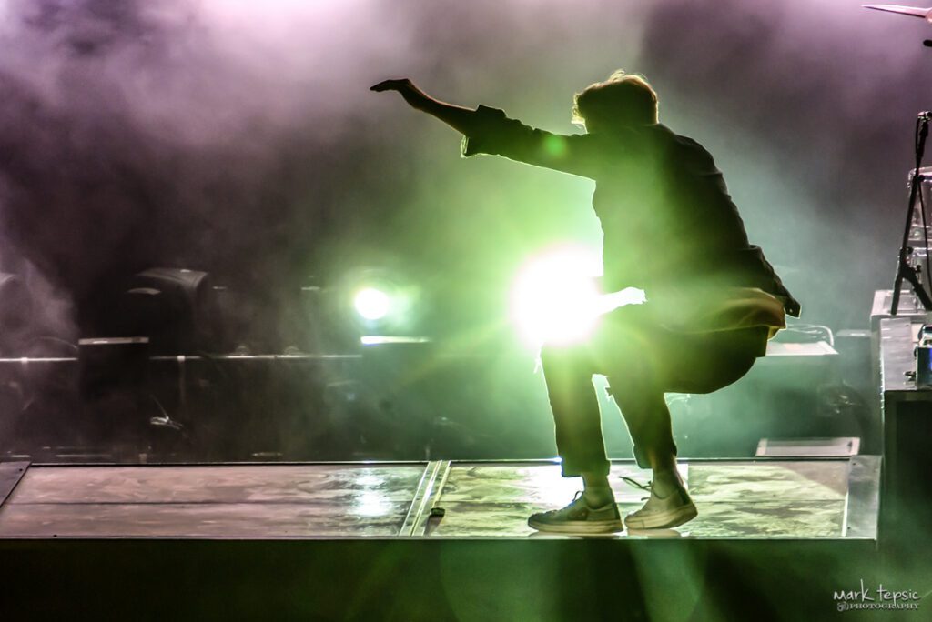 Performer on stage with dramatic lighting effect.