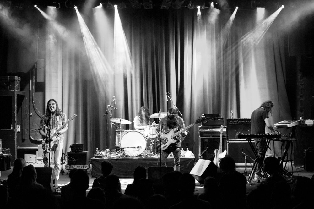 Band performing on stage with instruments.