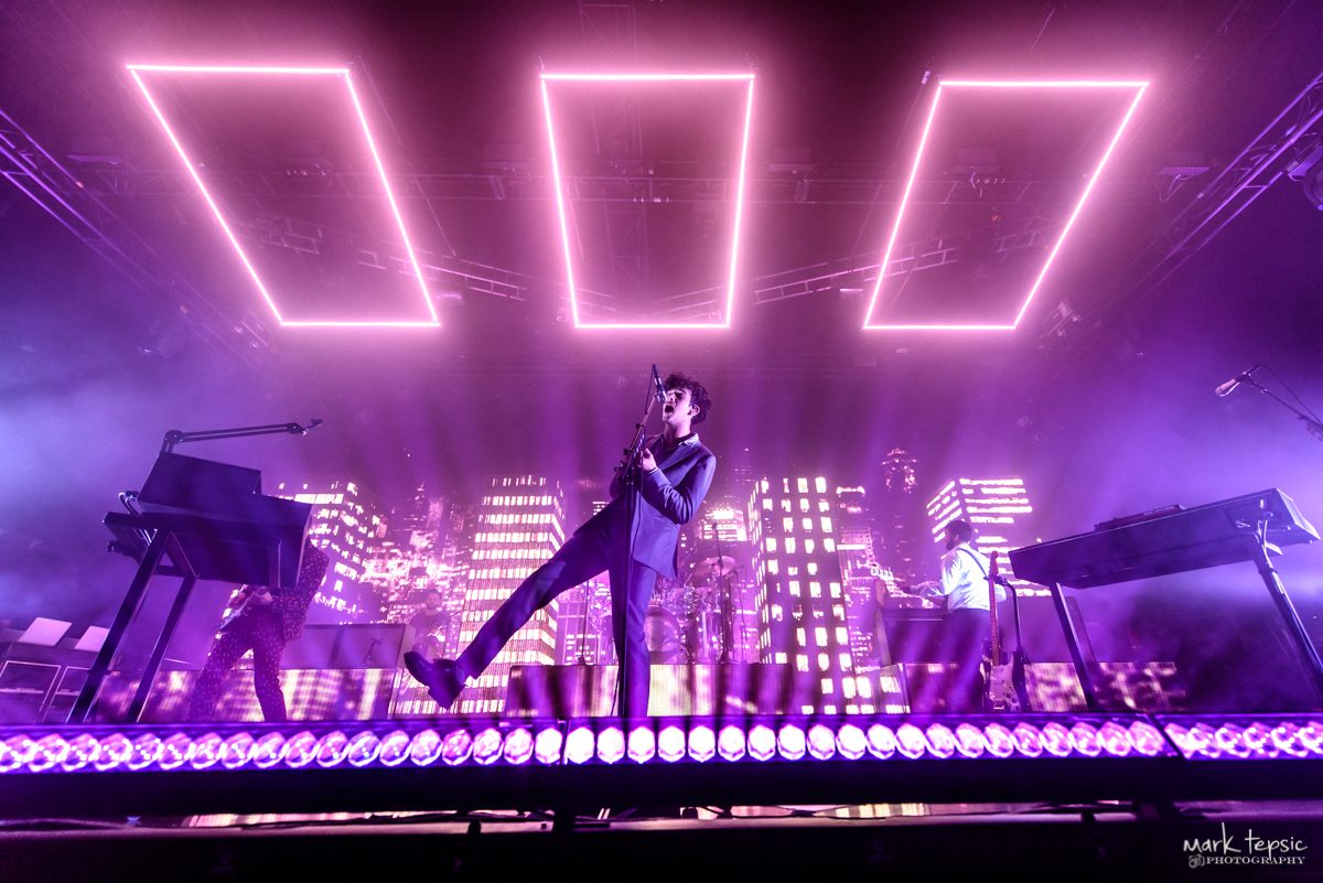 Concert stage with vibrant purple lighting effects.
