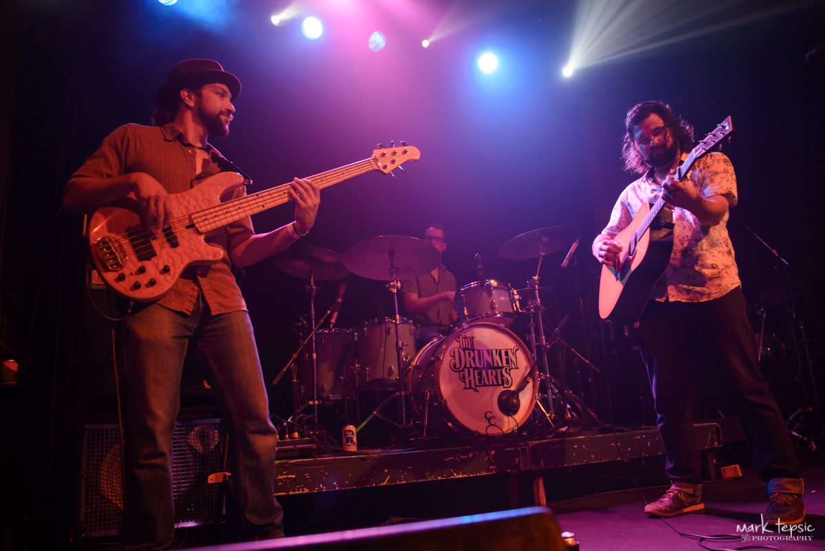 Band performing on stage with colorful lights.