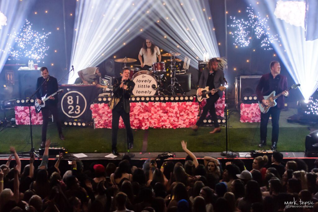 Band performing on stage with colorful lights.