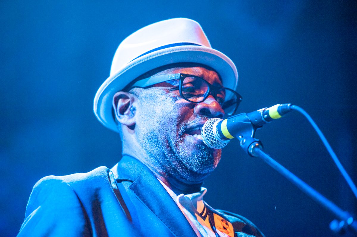 Singer performing on stage with a microphone.