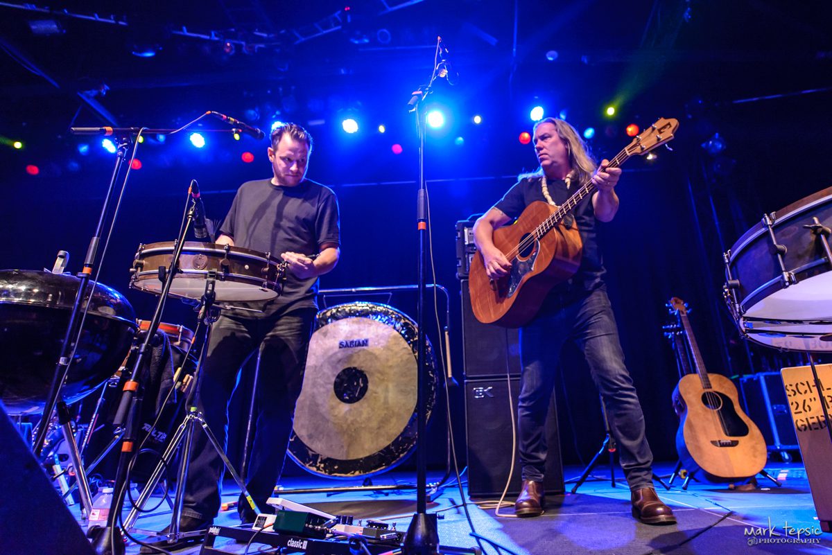Musicians performing on stage with instruments.