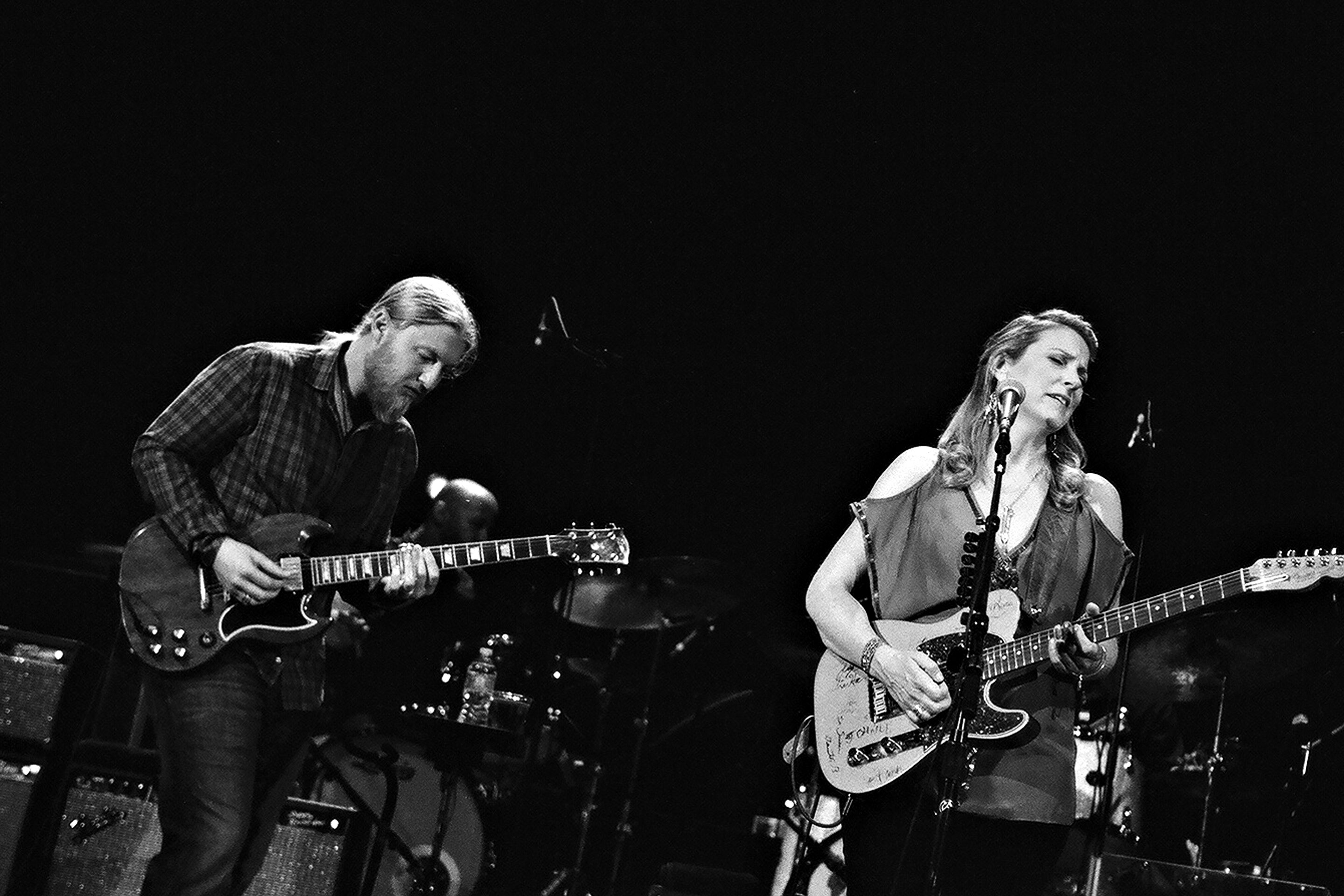 Musicians performing on stage with guitars.