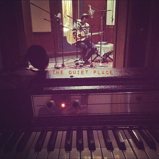 Recording studio with musician playing guitar.