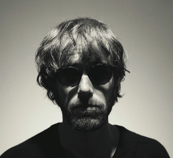 Man with sunglasses in dramatic lighting.