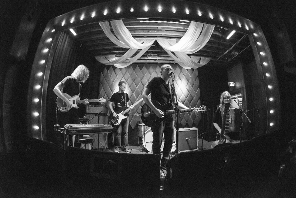 Band performing on stage in black and white.