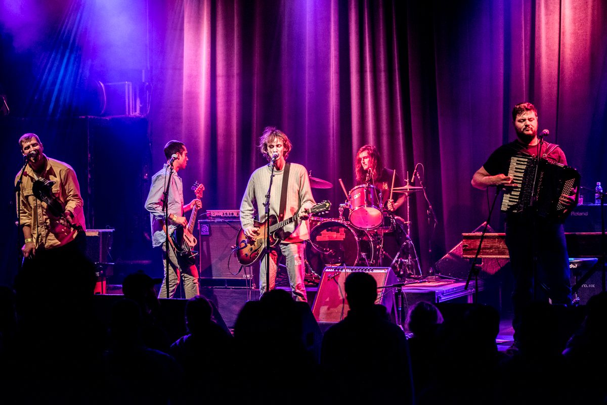 Band performing on stage with instruments.