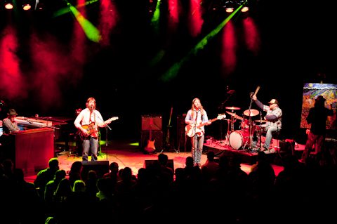 Band performing on stage with colorful lights.