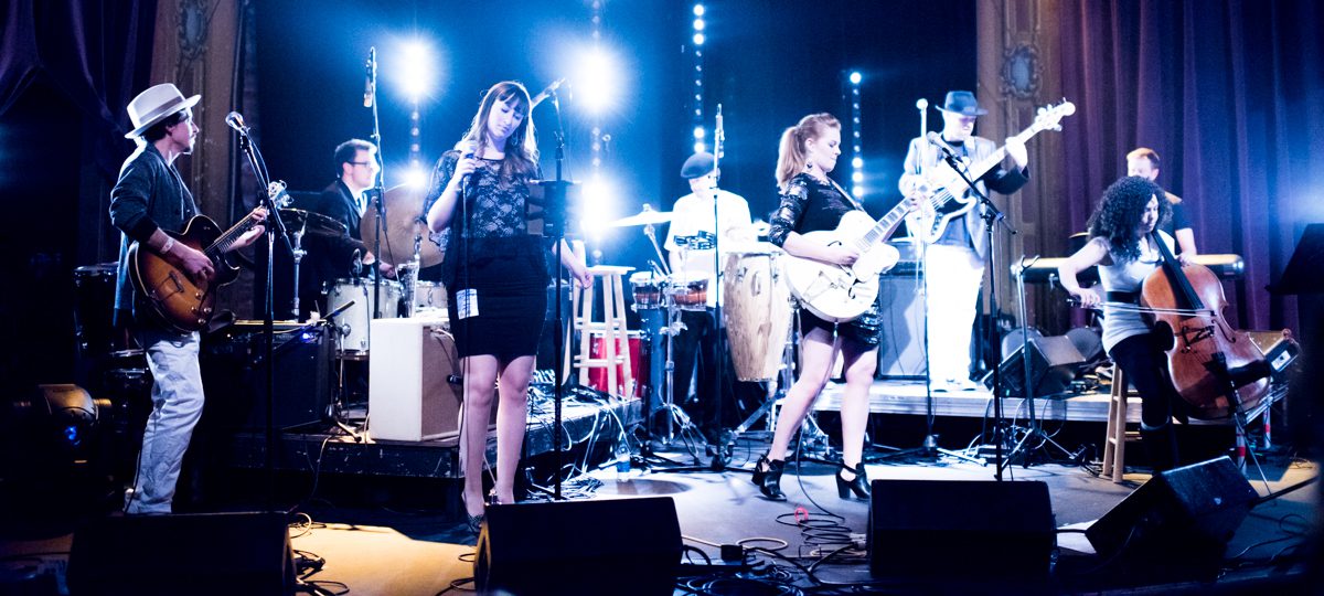 Band performing on stage with vibrant lighting.