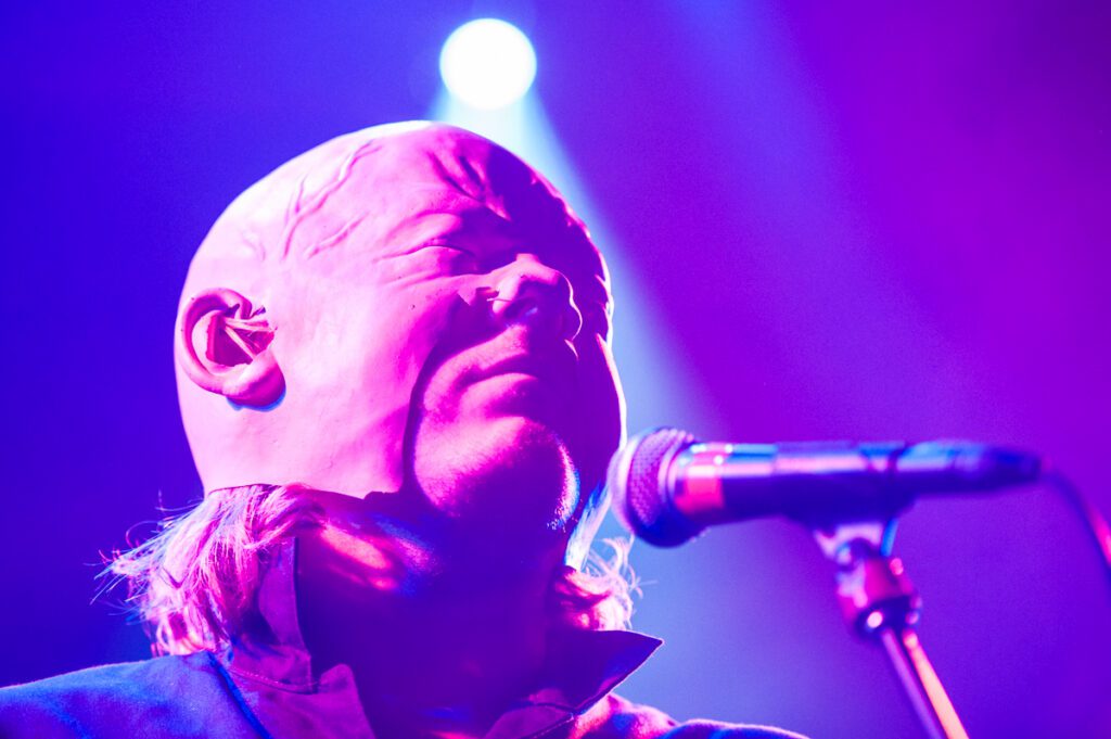 Singer performing under purple stage lights.