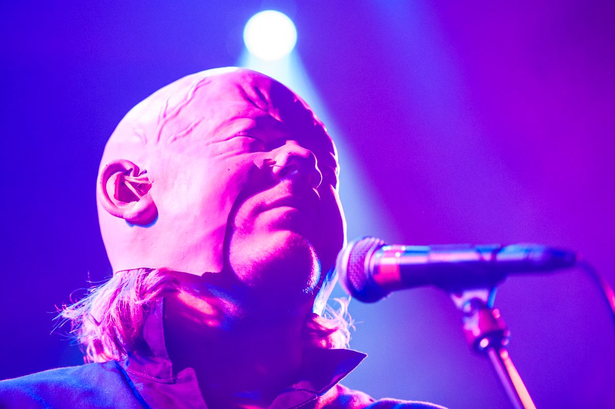 Singer performing under purple stage lights.