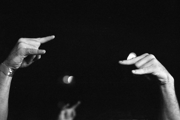 Hands gesturing against dark background.