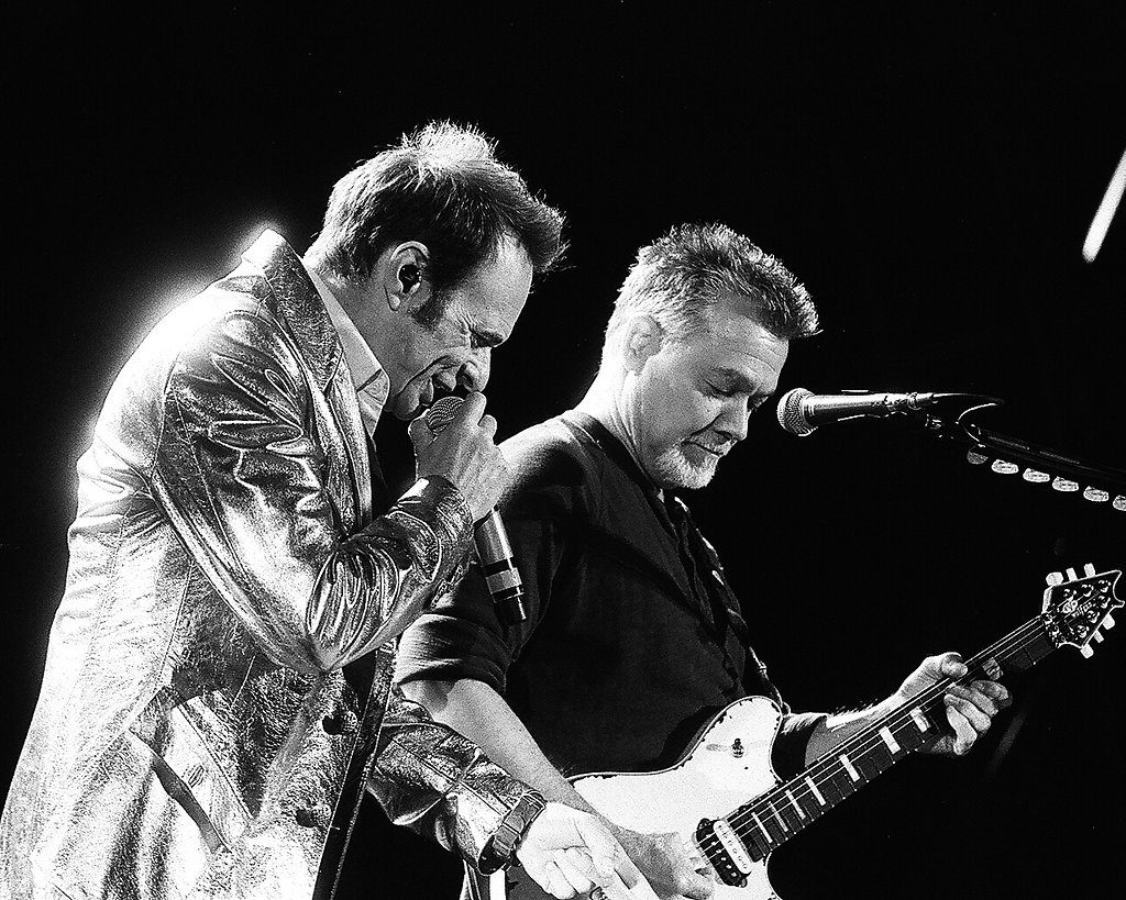 Two musicians performing on stage, black-and-white.