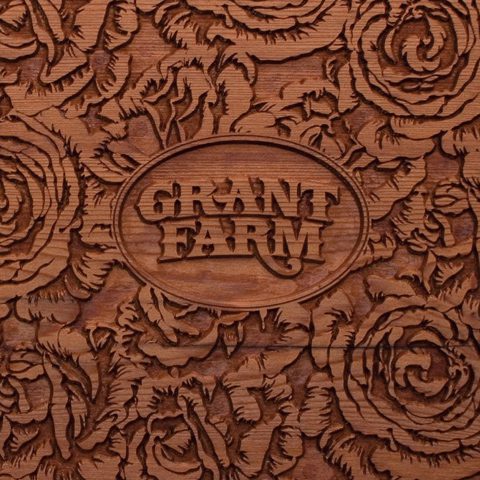 Wooden carving with "Grant Farm" and floral design.