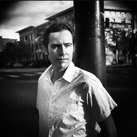 Man standing outdoors, black and white photo.