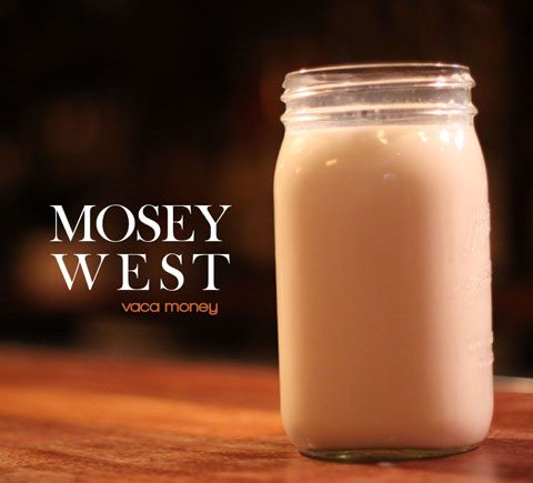 Mason jar of milk on wooden table.